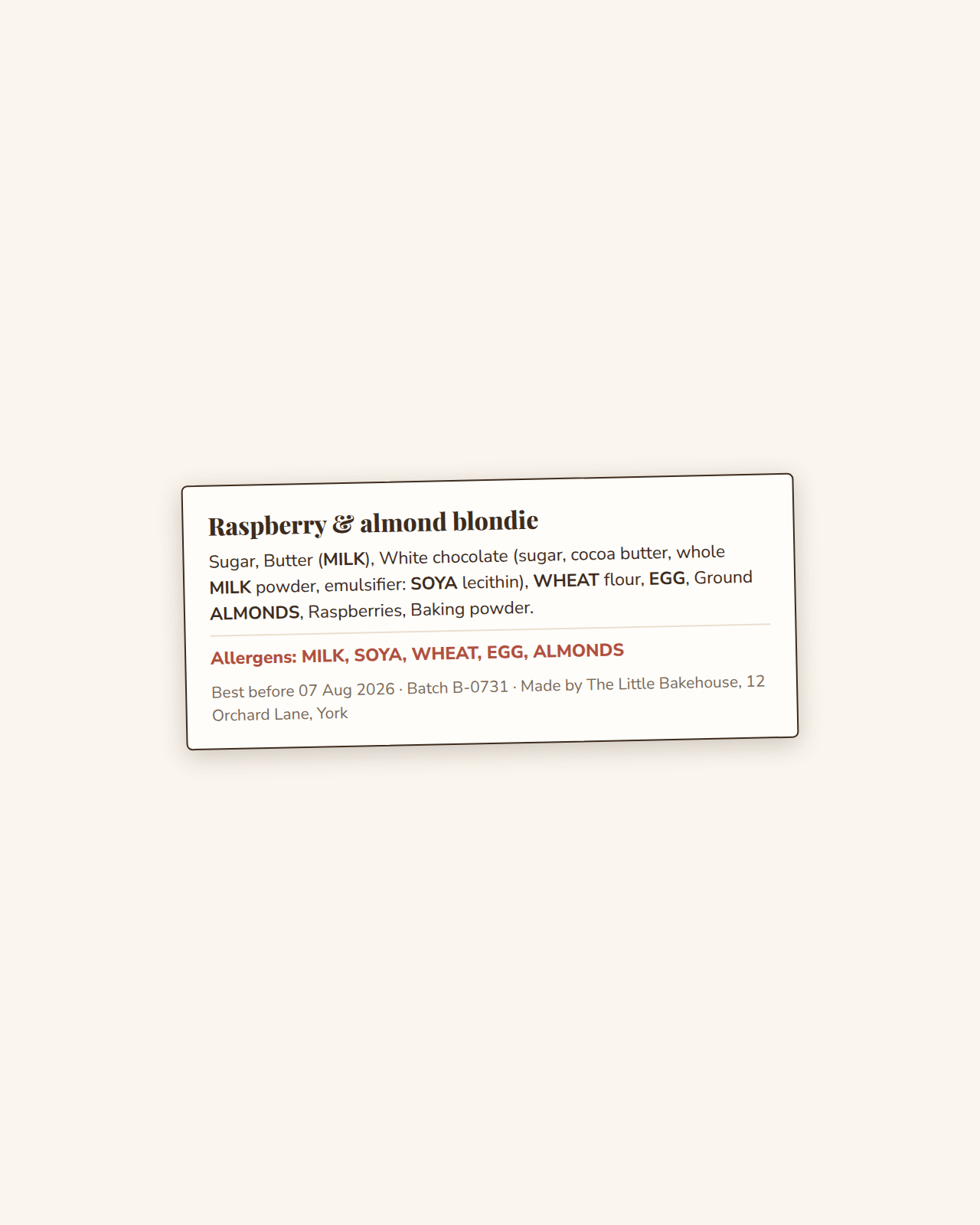 An example ProvenBatch label: Raspberry & almond blondie, full ingredient list with the allergens in bold capitals, a red allergens line, and a best-before, batch and business footer